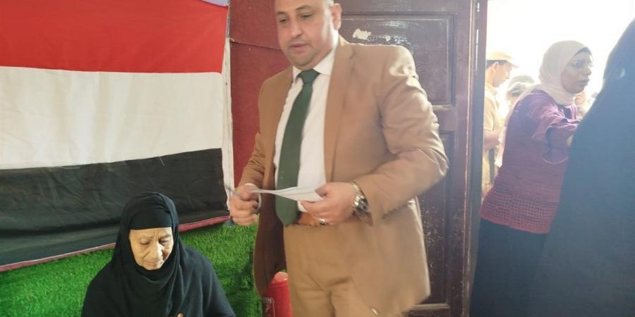 رئيس لجنة سيلا الابتدائية بالفيوم يساعد مسنّة على الإدلاء بصوتها