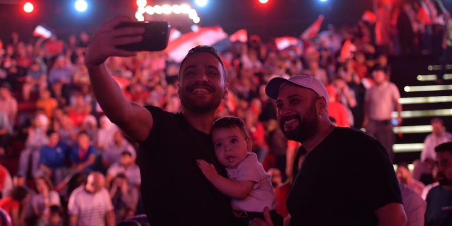حاتم صلاح وزوجته يشجعان منتخب مصر من العاصمة الجديدة